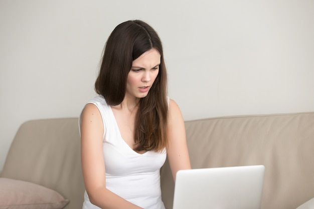 Stressed teen girl working on computer at home