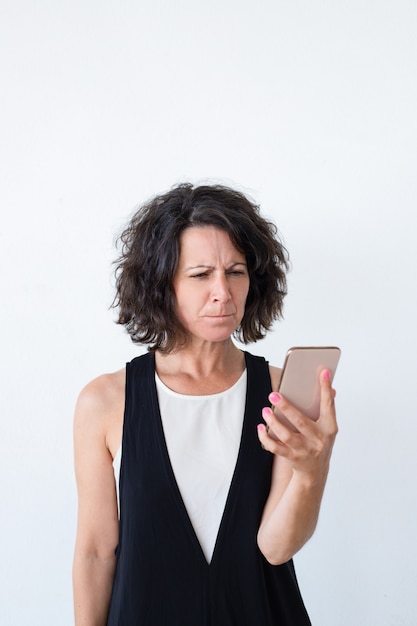 Stressed unhappy woman with smartphone getting bad new