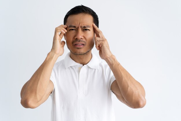 Stressed young man suffering from headache