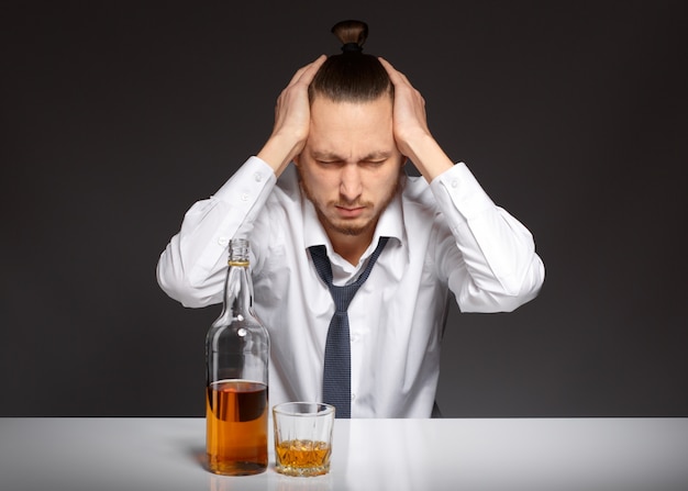 Free photo stressed young man touching his head