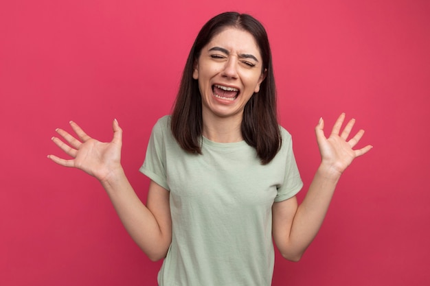 Stressed young pretty caucasian woman showing empty hands screaming with closed eyes