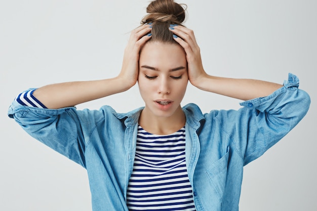 Stressed young woman with both hands on head