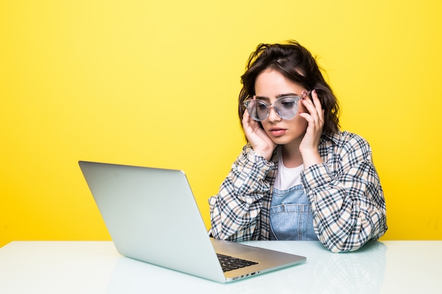 Stressed young woman working on a laptop isolated