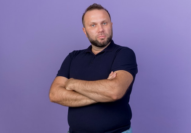 Strict adult slavic man standing with closed posture looking isolated