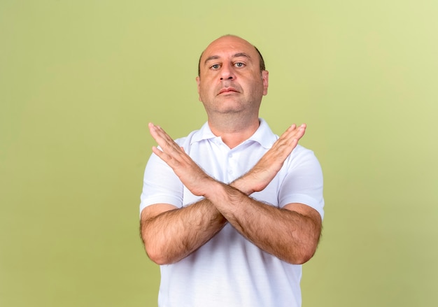 Free photo strict mature man showing gesture of no isolated on olive green wall