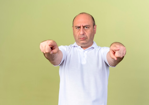 Strict mature man showing you gesture isolated on olive green wall