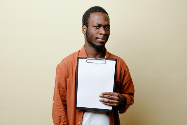 Strict young african american male holding clipboard isolated on white background