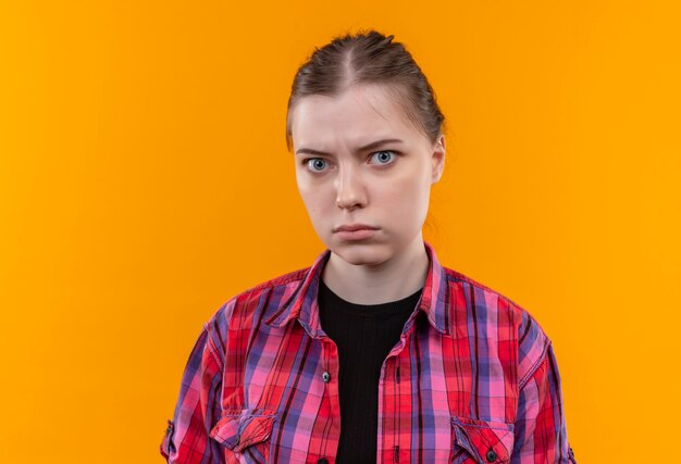  strict young beautiful woman wearing red shirt on isolated yellow wall