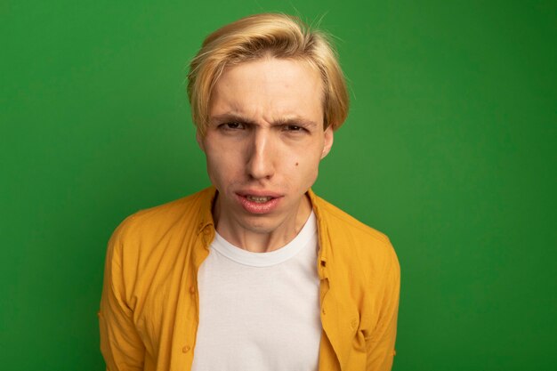 Strict young blonde guy wearing yellow t-shirt