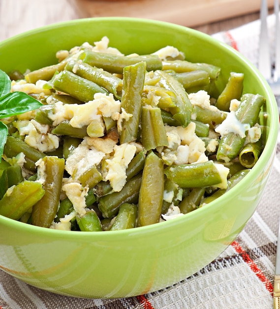 String beans with eggs in bowl.
