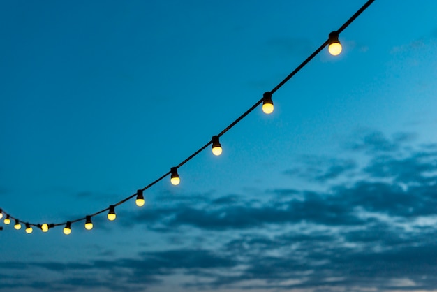 Free photo string of lights with sunset sky