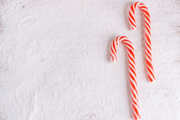 Free photo striped candy canes on powdered sugar