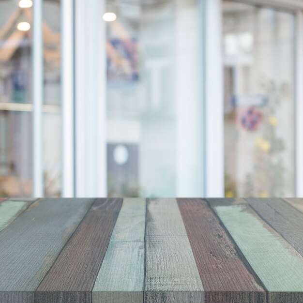 Striped wooden table in front of glass window