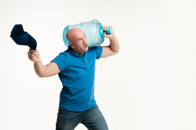 Strong delivery man carrying water bottle