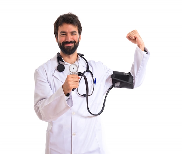 Strong doctor with blood pressure monitor over white background