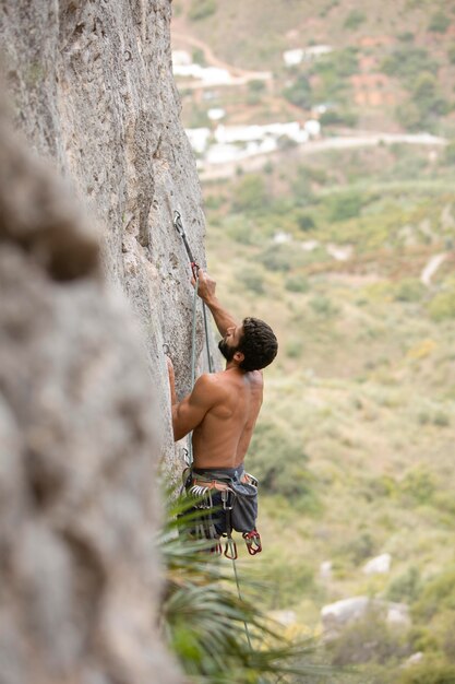 Strong man climbing on a mountain