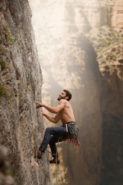 Strong man climbing on a mountain