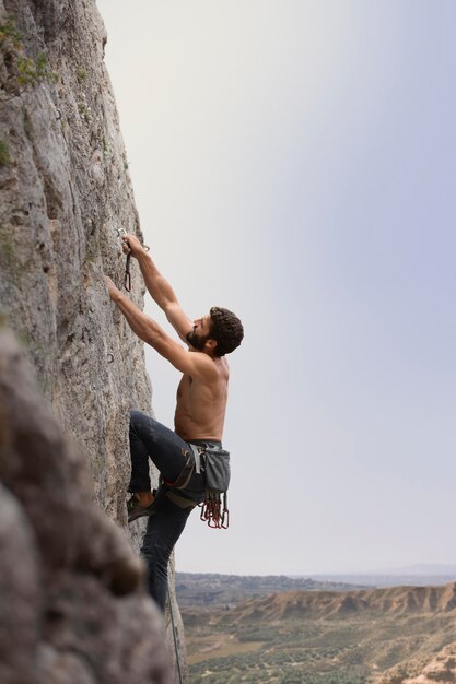 Strong man climbing on a mountain