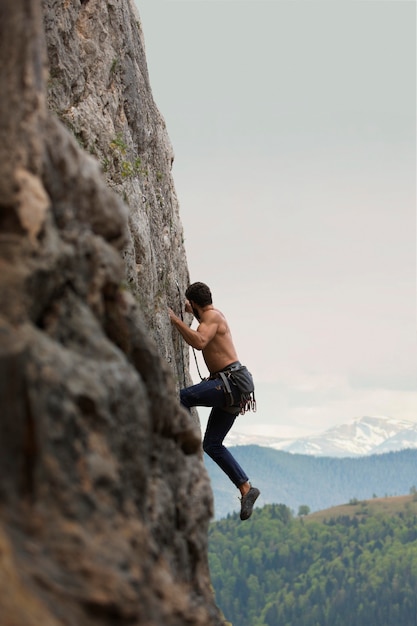 Strong man climbing on a mountain