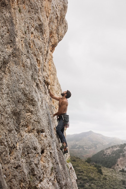 Free photo strong man climbing on a mountain