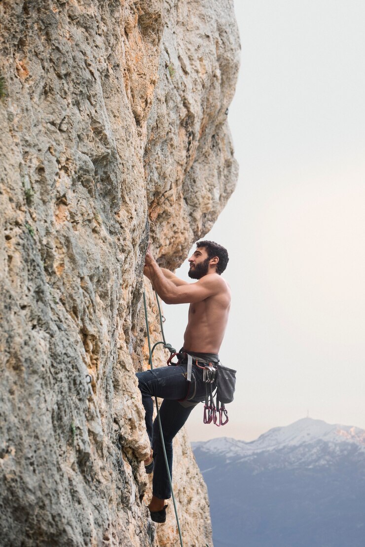Free Photo strong man climbing on a mountain