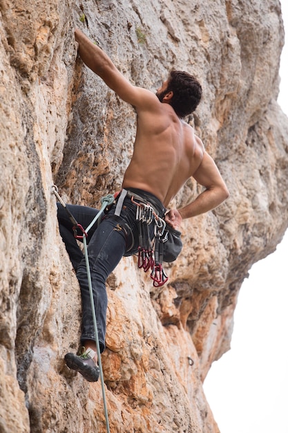 Free photo strong man climbing on a mountain