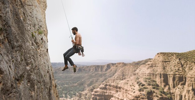 Strong man climbing on a mountain