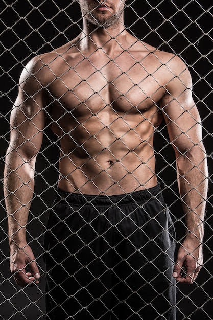 Strong man on fence with chains