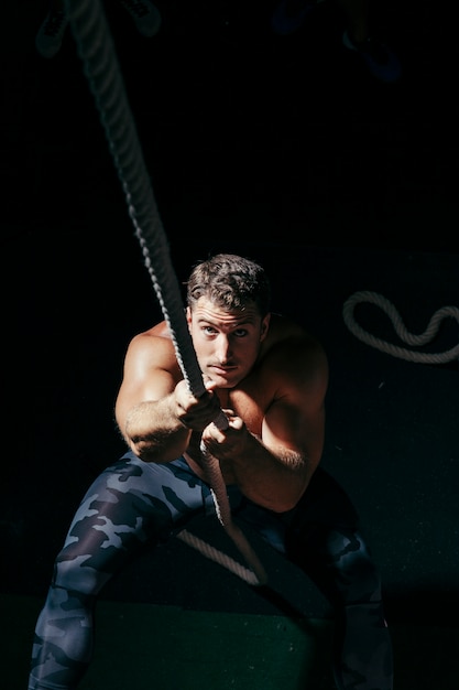 Free photo strong man pulling on rope