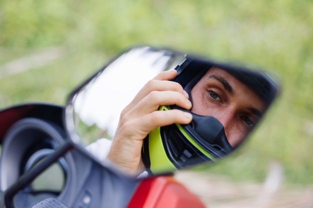 Strong man on tropical jungle field with red motorbike