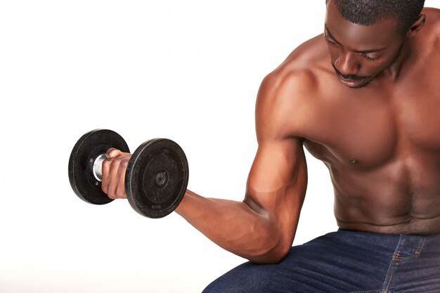 Strong and muscular guy with dumbbell isolated on white 