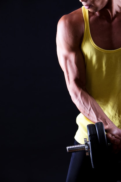 Strong and muscular guy with dumbbell