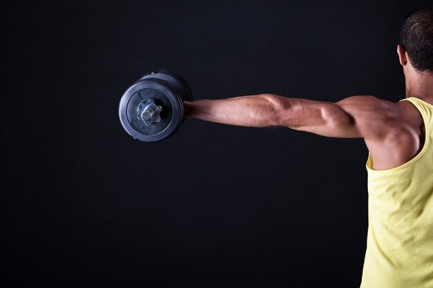 Strong and muscular guy with dumbbell