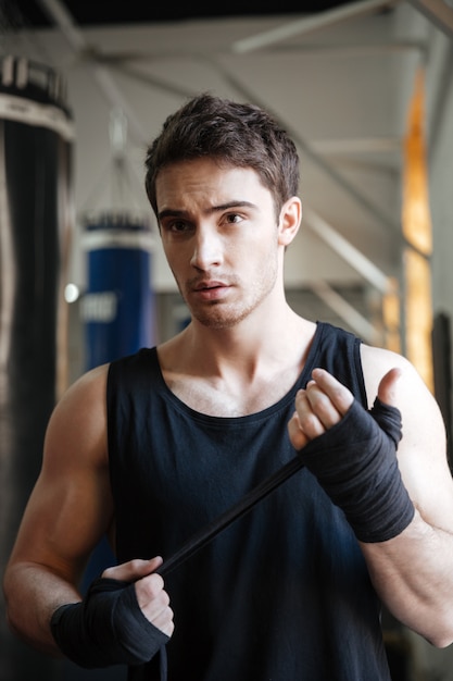 Strong serious sportsman looking away while training