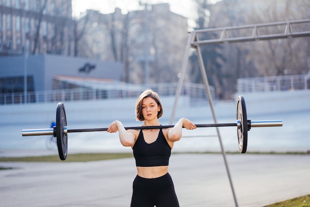 Strong woman exercising with barbell sports fitness concept