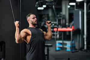 Free photo strongman keeping muscles in tense while training in gym