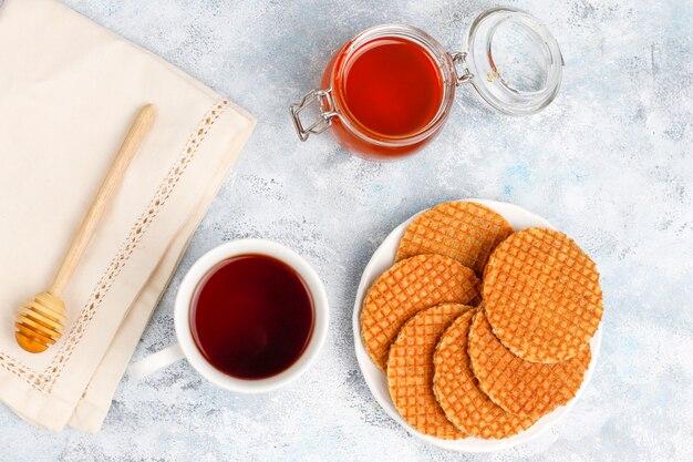 Stroopwafels, Caramel Dutch Waffles с чаем или кофе и медом на бетоне