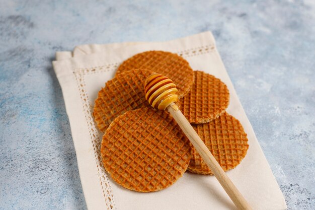 Stroopwafels, Caramel Dutch Waffles with tea or coffee and honey on concrete 