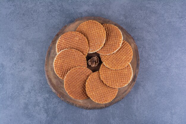 돌에 나무 접시에 고립 된 pinecone와 Stroopwafels. 고품질 사진