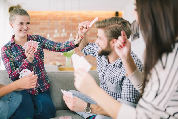 Struggling friends playing cards on party