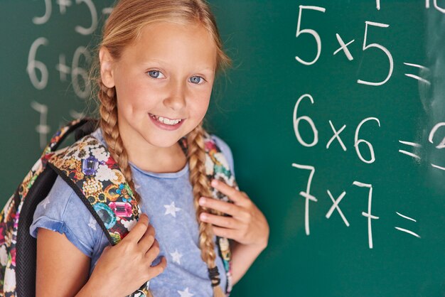 Student next to blackboard with numbers