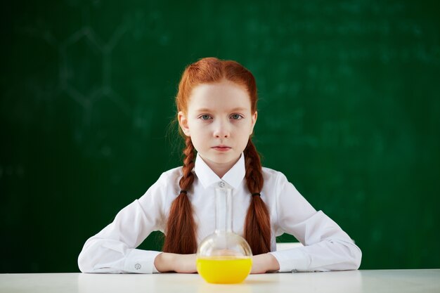 Student in chemistry class with blackboard background