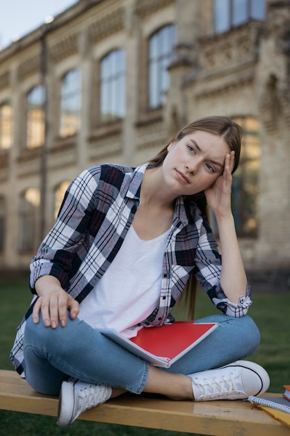 試験結果に失望した学生。試験の失敗、ベンチに座って疲れた顔で不幸な女性 Premium写真
