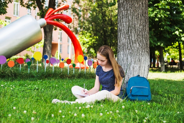 芝生で宿題をしている学生