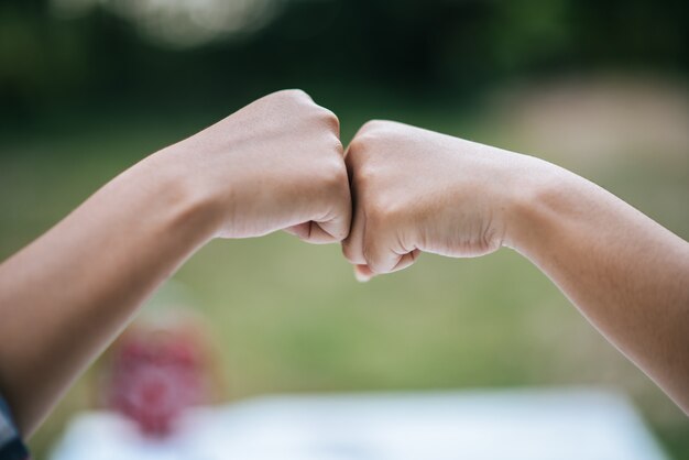 Студенческая девушка дает успех Fist Bump для изучения