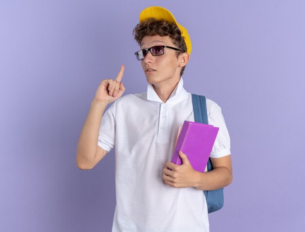 Student guy in white polo shirt and yellow cap wearing glasses