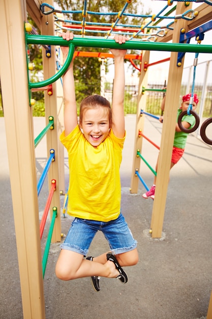 Student hanging from the green bar