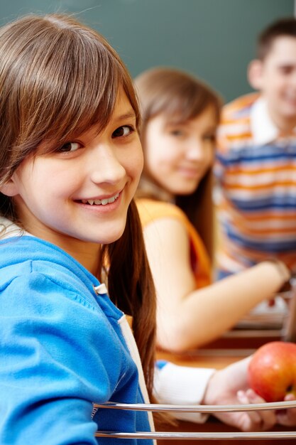 Student holding an apple in class