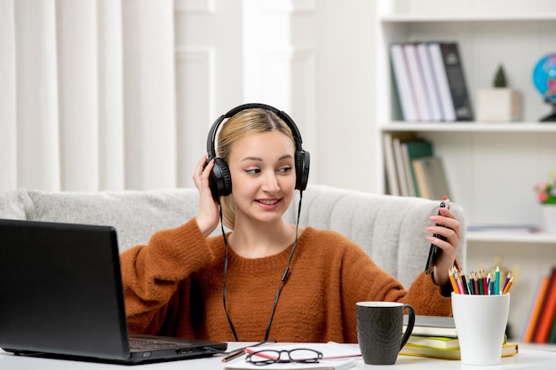 Студент онлайн милая девушка в очках и свитере учится на компьютере, делая селфи