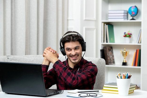 Student online cute guy in checked shirt with glasses studying on computer holding hands together